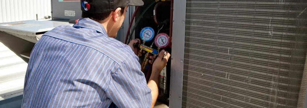 HVAC technician servicing a condenser unit in Lebanon